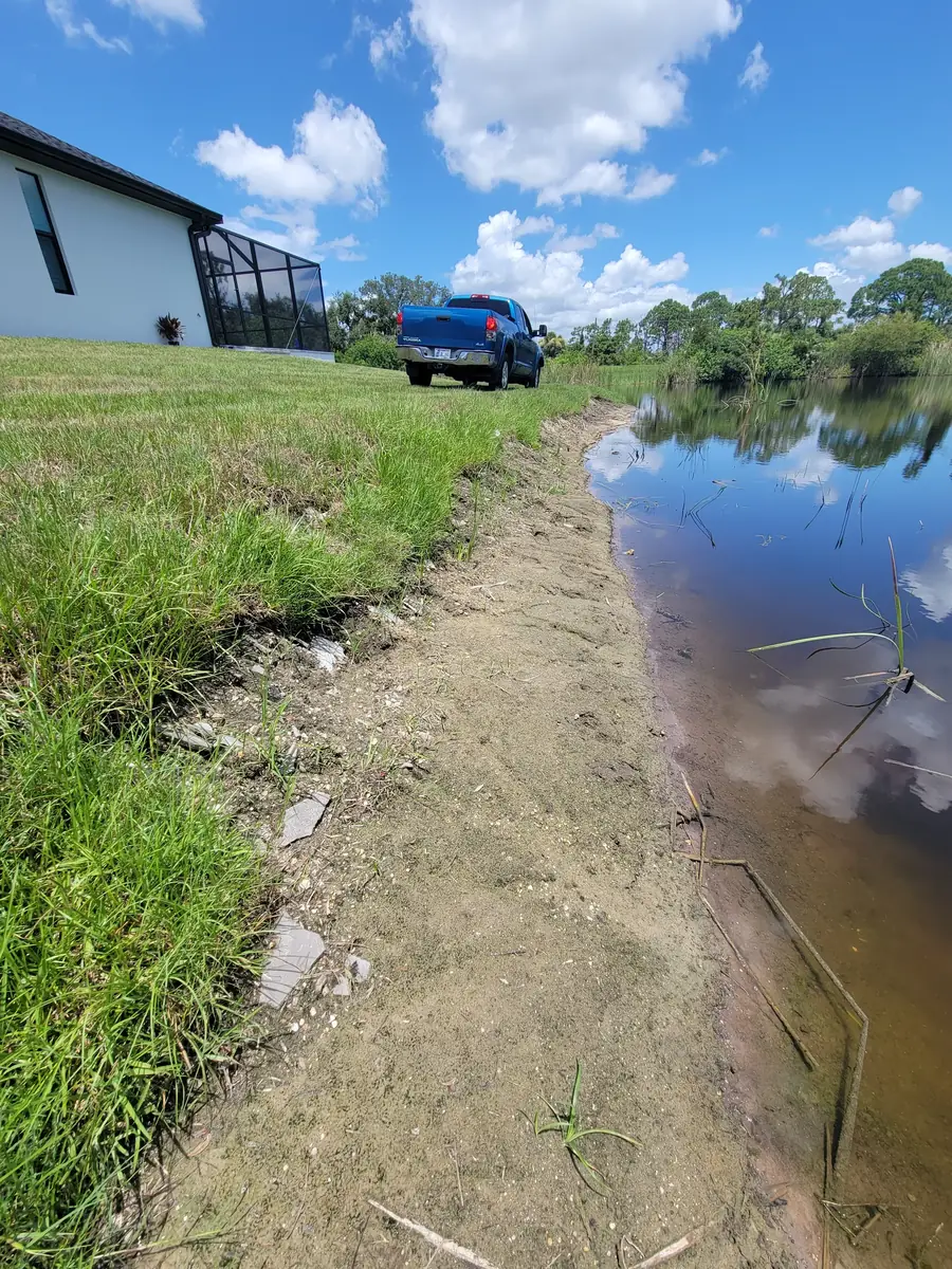 Rip rap rock embankment installed along an eroded retention pond bank