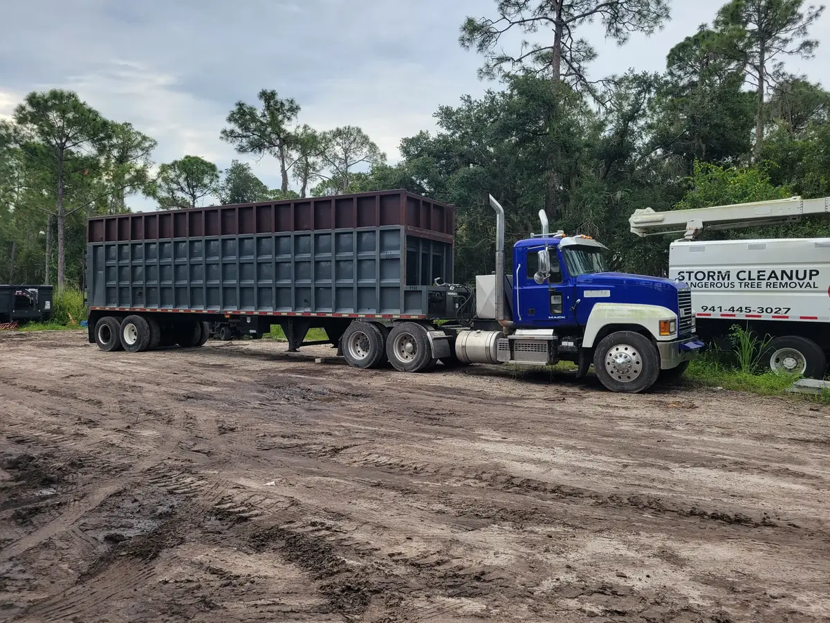 Mack tractor and open top debris trailer staged next to a lettered ACI bucket truck
